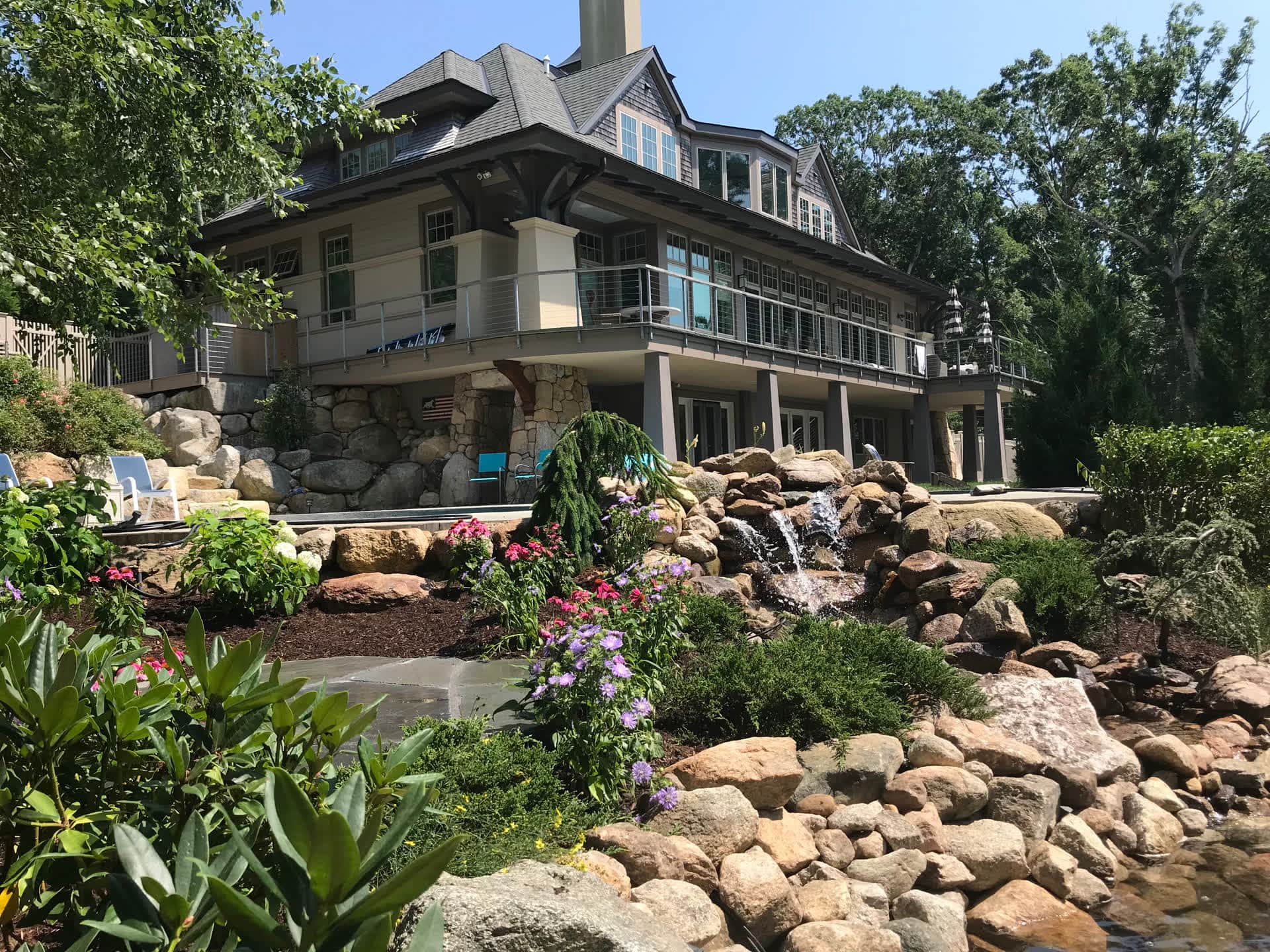 Landscaped front yard with waterfall garden and flower beds in Massachusetts